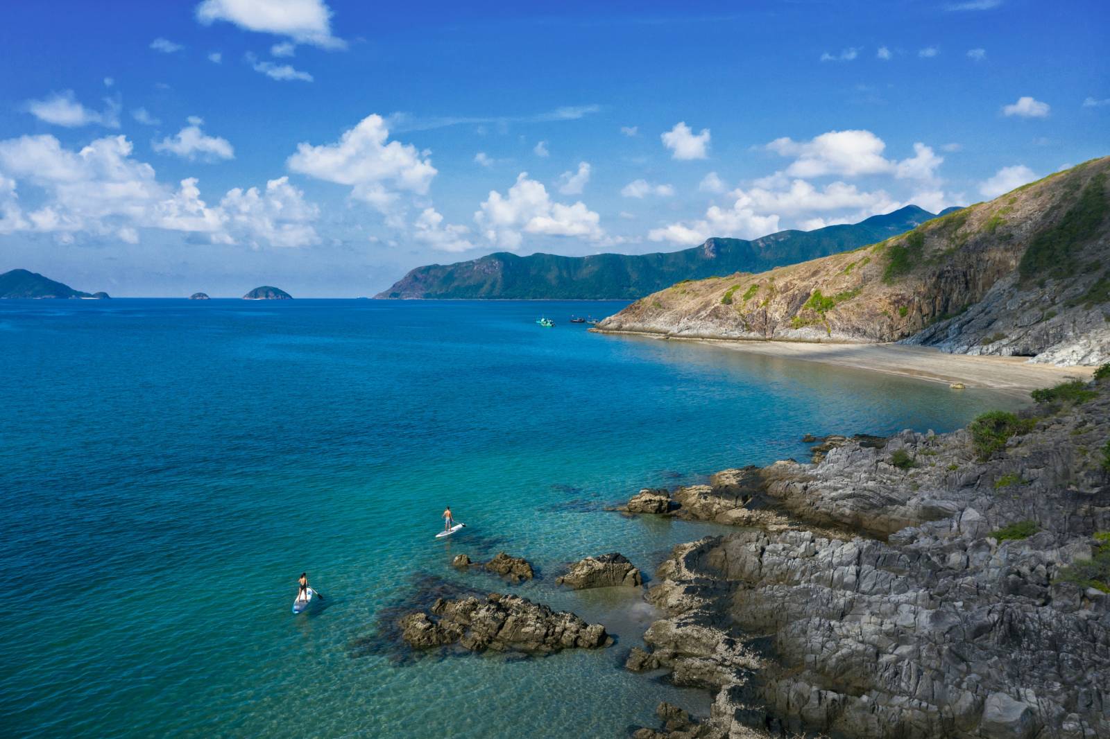 Couple paddle boarding on the blue ocean of Con Dao