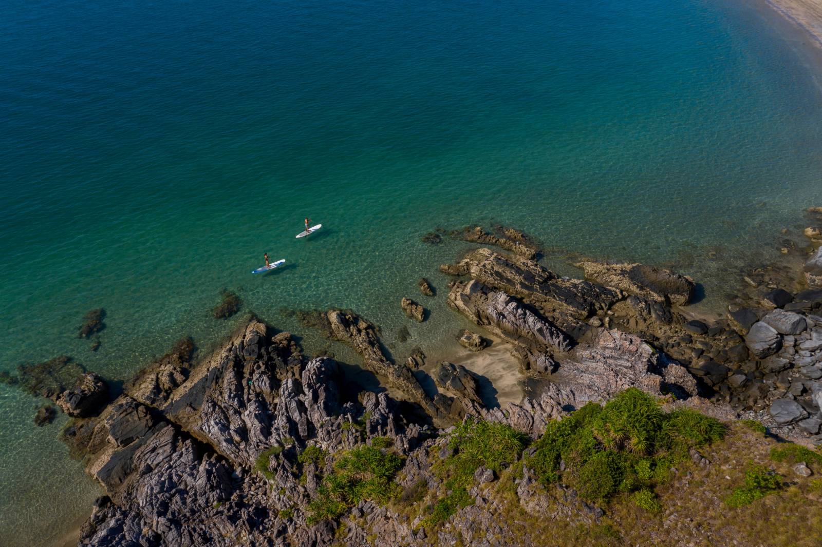 Couple paddle boarding on the blue ocean of Con Dao