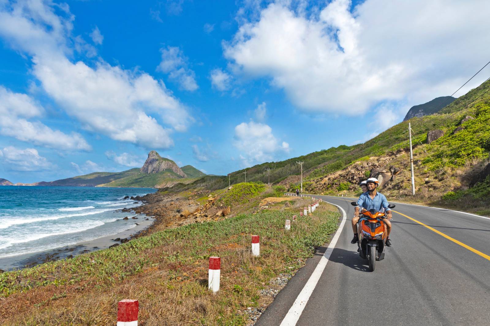 Couple biking along the sea road of Con Dao